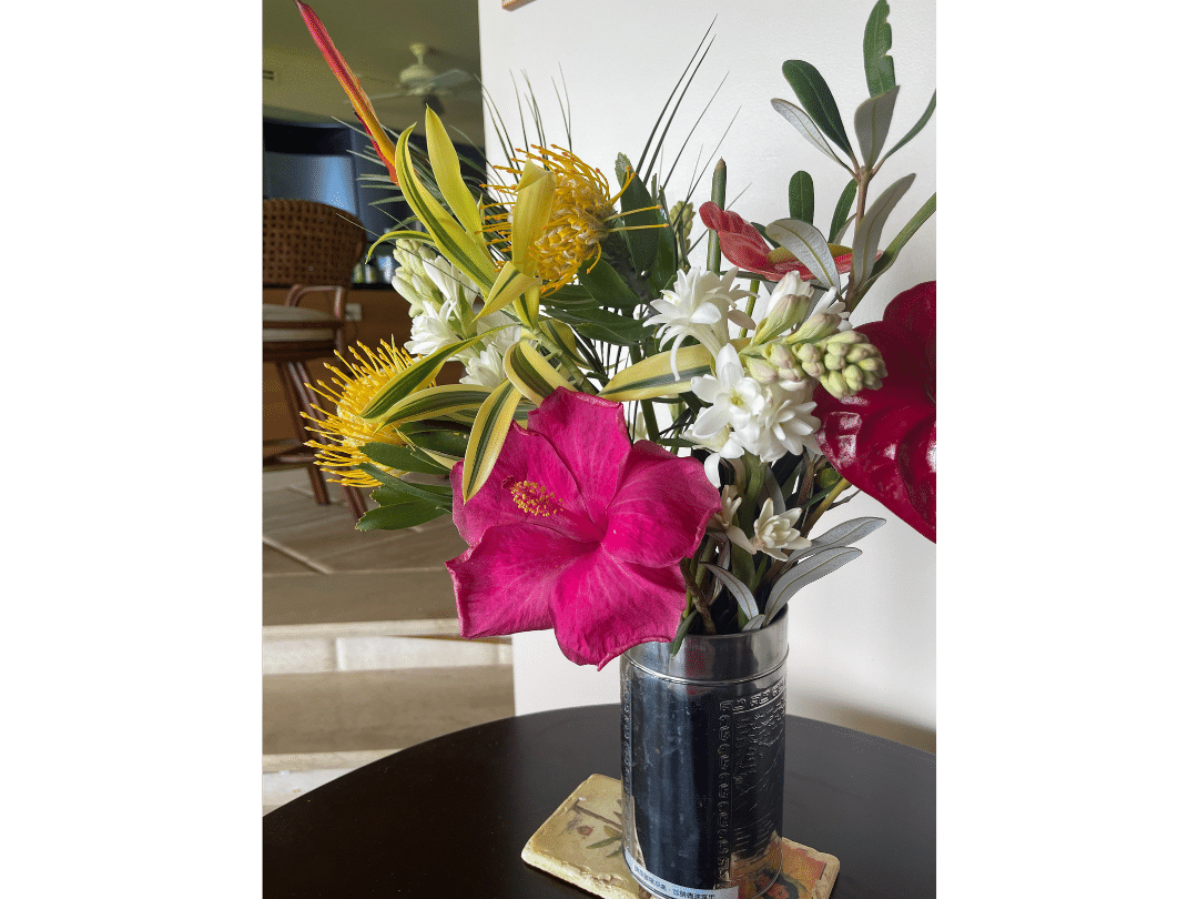 colorful floral arrangement including a vibrant pink hibiscus bloom