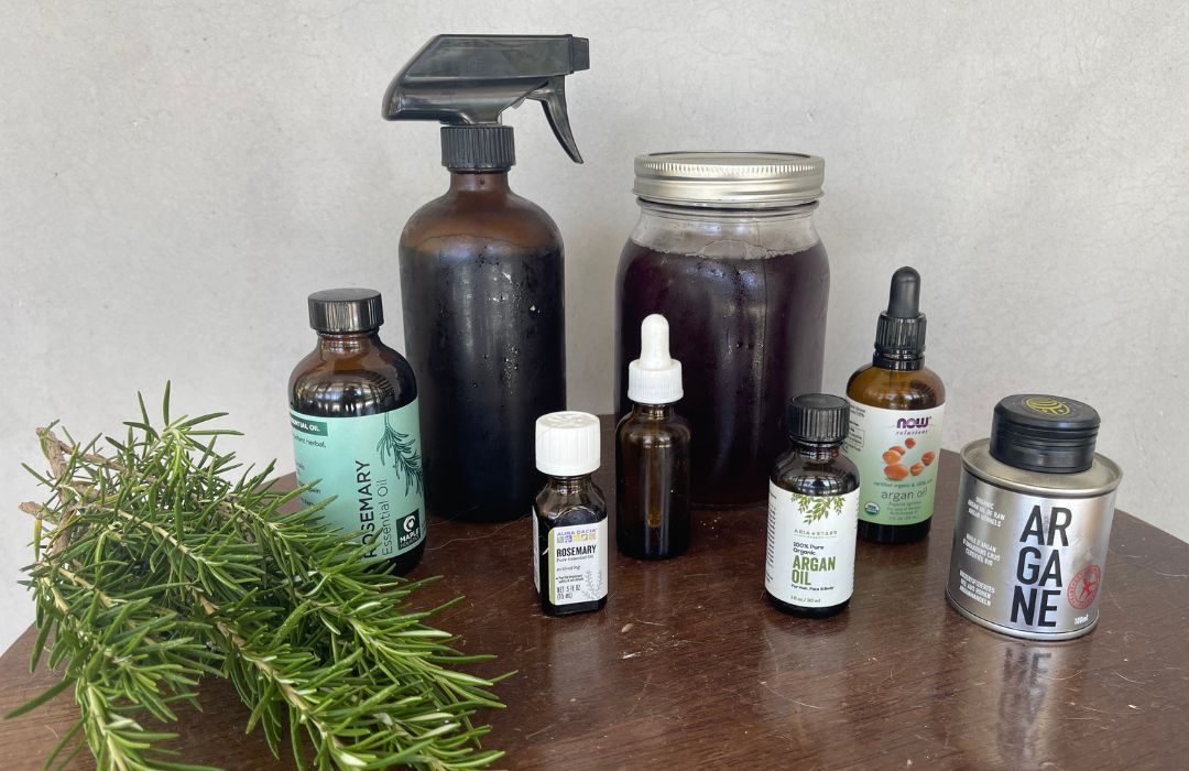 countertop with rosemary springs, a spray bottle and aromatherapy dropper bottles